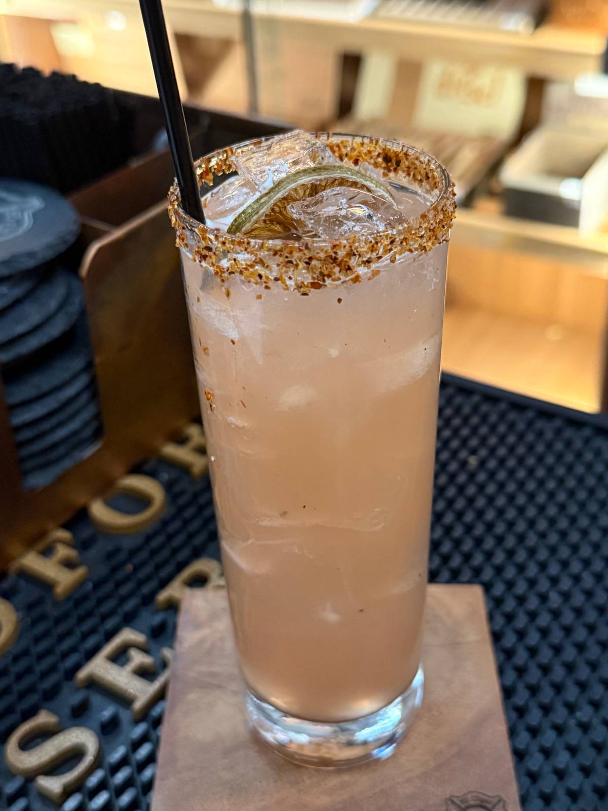 Spicy Paloma in a tall collins glass with a chili-lime rim, dried lime wheel and crushed ice