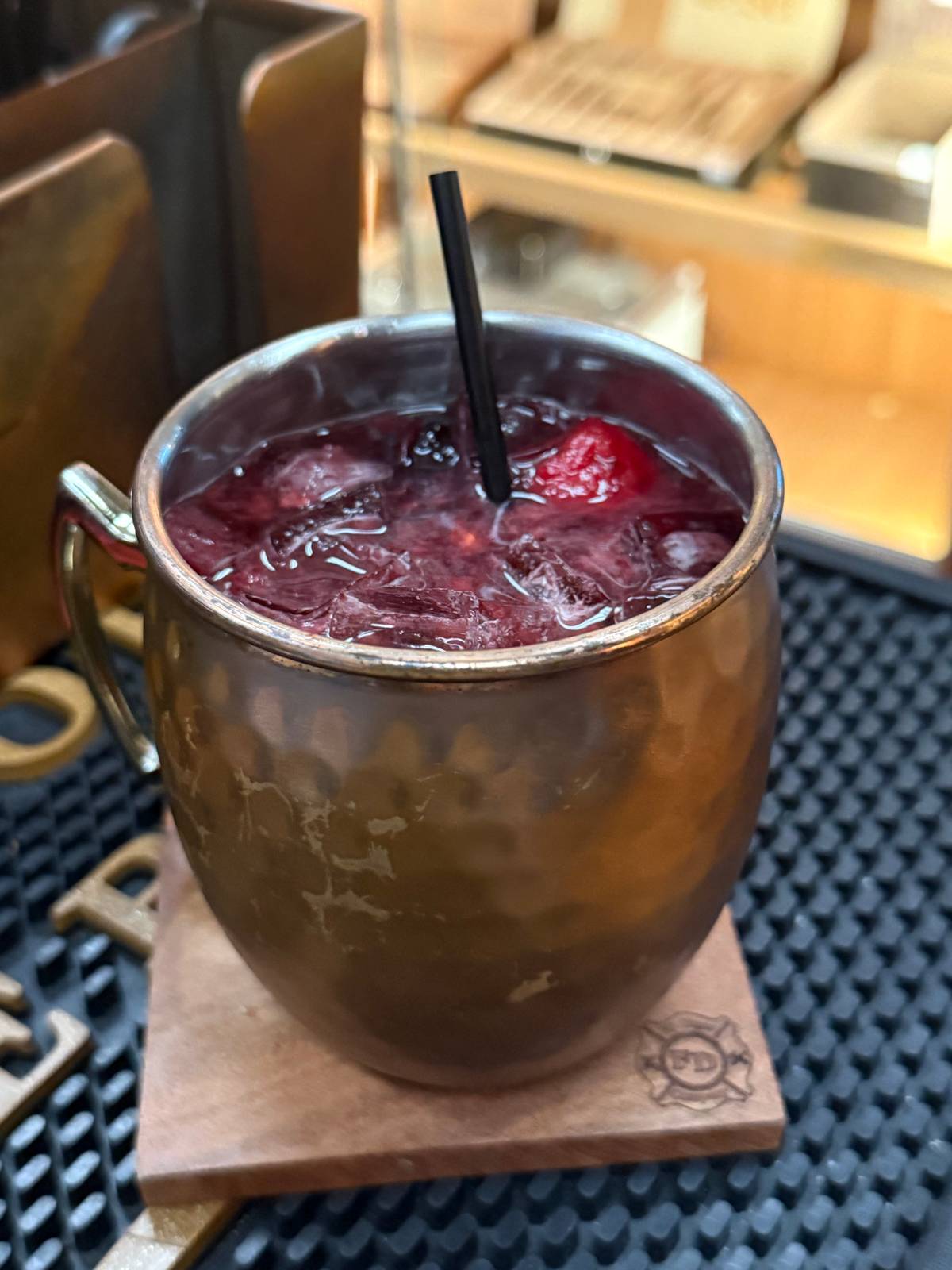Triple Berry Mule served in a copper mule mug over ice with fresh blackberries, blueberries and raspberries