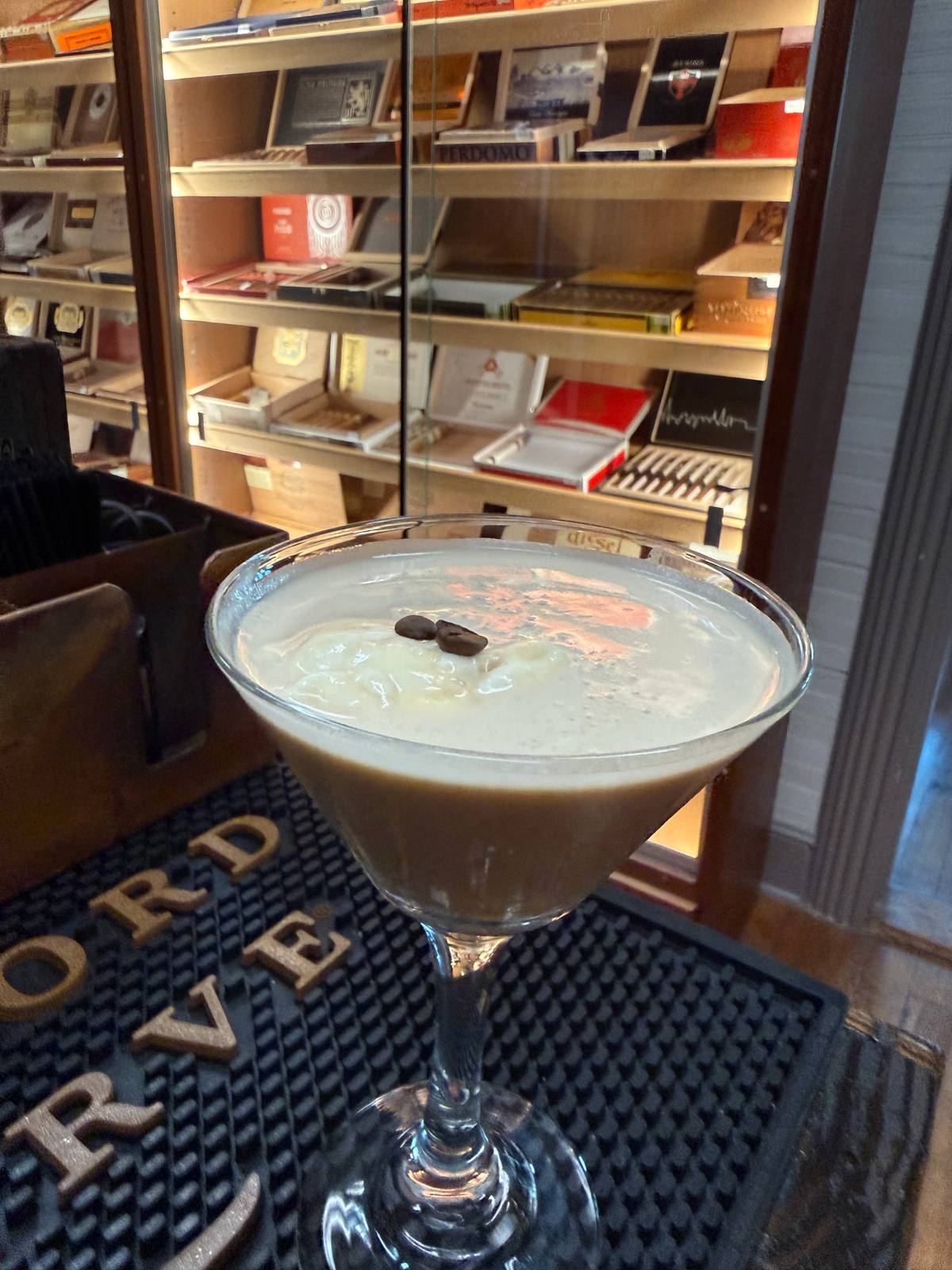 Vanilla Espresso Martini in a coupe glass with a creamy foam top, dusted with cocoa and garnished with espresso beans